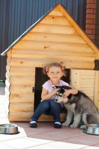 Mädchen mit Hund vor Hütte